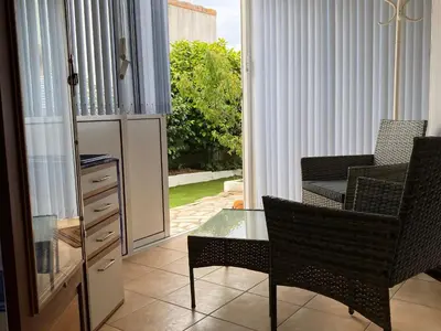 Coin salon dans l'établissement Chambre cosy RDC avec véranda, jardin privé et wifi, proche plage – Saint-Michel-Chef-Chef - FR-1-306-1256