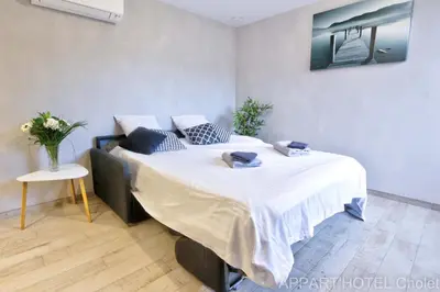 Un ou plusieurs lits dans un hébergement de l'établissement Appart hotel Cholet Carteron