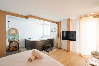 Télévision ou salle de divertissement dans l'établissement La Parenthèse Gemmoise avec jacuzzi privatif