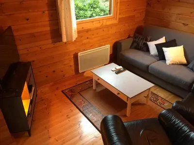 Coin salon dans l'établissement Charmante maison en bois pour 5 personnes avec terrasse et jardin - FR-1-426-580