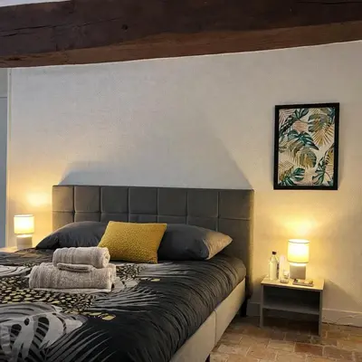 Un ou plusieurs lits dans un hébergement de l'établissement Studio de charme avec cheminée décorative