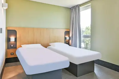 Un ou plusieurs lits dans un hébergement de l'établissement B&B HOTEL La Roche-sur-Yon