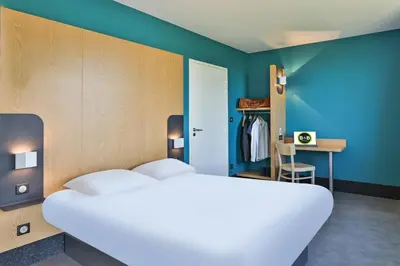Un ou plusieurs lits dans un hébergement de l'établissement B&B HOTEL La Roche-sur-Yon