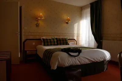Un ou plusieurs lits dans un hébergement de l'établissement Logis Hotels Le Champalud Restaurant La Citadelle