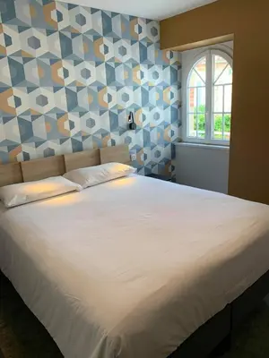 Un ou plusieurs lits dans un hébergement de l'établissement Hotel - Restaurant Les 3 Piliers