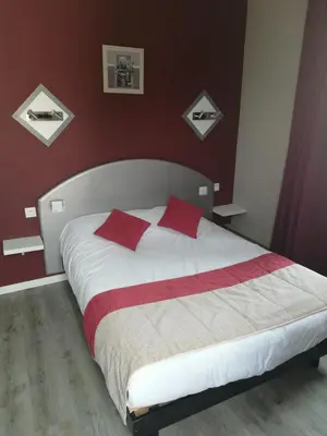 Un ou plusieurs lits dans un hébergement de l'établissement Hôtel-restaurant Les Colonnades