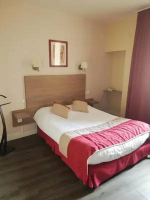 Un ou plusieurs lits dans un hébergement de l'établissement Hôtel-restaurant Les Colonnades