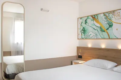 Un ou plusieurs lits dans un hébergement de l'établissement Brit Hotel Angers Parc Expo - L'Acropole