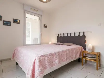 Un ou plusieurs lits dans un hébergement de l'établissement Appartement Calme Proche Plage avec Terrasse Sud, Parking Sécurisé et Équipements Complets - FR-1-306-909