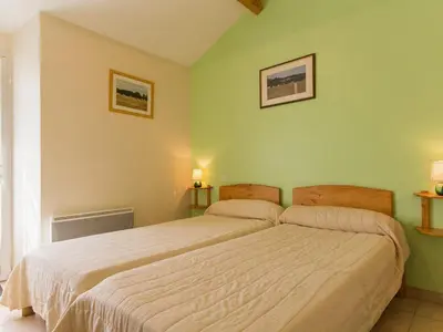 Un ou plusieurs lits dans un hébergement de l'établissement Gîte spacieux avec jardin, SPA, et équipements bébé près de Pornic - FR-1-306-1041