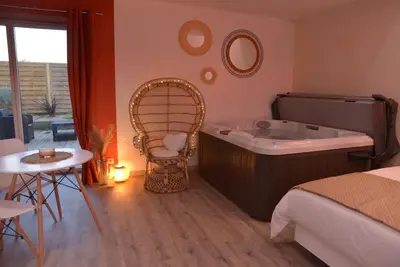Un ou plusieurs lits dans un hébergement de l'établissement L'Evasion chambre DUNE avec sauna et spa privatifs