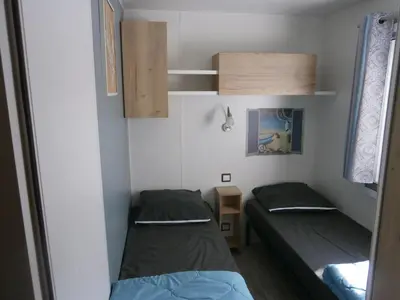 Un ou plusieurs lits dans un hébergement de l'établissement Mobilhome 3 chambres tout confort, proche de la plage