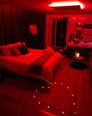 Un ou plusieurs lits dans un hébergement de l'établissement L'Evasion chambre MONTMARTRE avec Jacuzzi privatif